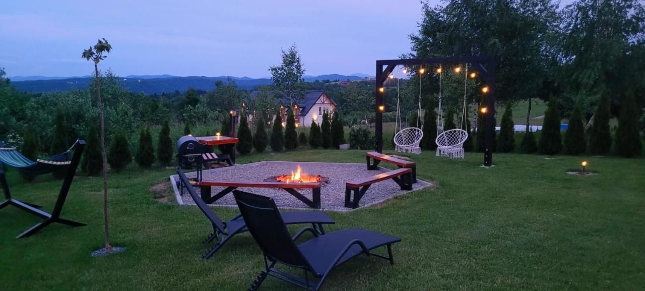 Ogród o zmierzchu z leżakami i wiszącymi fotelami
